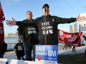 Unifor executives Dave Cassidy, left, and John D'Agnolo speak to a large crowd concerned with the scheduled closing of GM's Oshawa assembly plant.