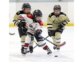 Tecumseh's T.J. Lebel, centre, controls the puck in front of LaSalle's Noah Deschamps, left, and Matthew Seguin in atom division on Dec. 27, 2018, at Lakeshore's Atlas Tube Centre during the 23rd annual Hockey for Hospice Tournament.