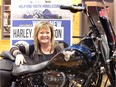 Donna Roy, Windsor Youth Centre program manager, gets a close-up feel for the 2018 Harley-Davidson 115th Anniversary Heritage Classic motorbike that one lucky winner gets to ride after a raffle draw on Dec. 29, 2018, at Thunder Road Harley-Davidson on Huron Church Road.