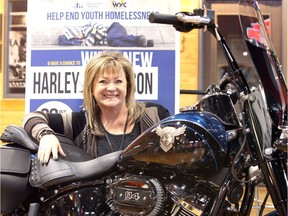 Donna Roy, Windsor Youth Centre program manager, gets a close-up feel for the 2018 Harley-Davidson 115th Anniversary Heritage Classic motorbike that one lucky winner gets to ride after a raffle draw on Dec. 29, 2018, at Thunder Road Harley-Davidson on Huron Church Road.