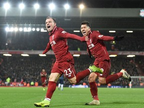 Liverpool's Swiss midfielder Xherdan Shaqiri celebrates with Liverpool's Brazilian midfielder Roberto Firmino (R) after scoring their third goal during the English Premier League football match between Liverpool and Manchester United at Anfield in Liverpool, north west England on December 16, 2018.