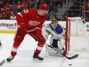 Detroit Red Wings center Michael Rasmussen plays the puck next to St. Louis Blues goaltender Jake Allen during the first period of an NHL hockey game on Nov. 28, 2018, in Detroit.