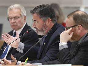 City councillor Kieran McKenzie, centre, makes a point about a proposal by CUPE to in-source parking enforcement services as councillors Jim Morrison, left, and Chris Holt look on during a council meeting on Monday, December 17, 2018.