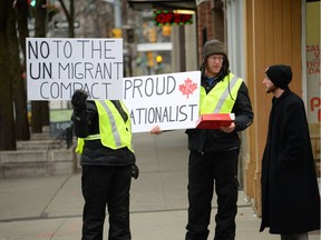 Mark and Carolin Mursall, two protesters with the Windsor chapter of Yellow Vests Canada, hold signs and speak to a passerby on the corner of Ouellette Avenue and University Avenue Saturday, December 22, 2018.