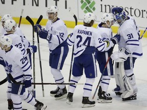 Toronto Maple Leafs goaltender Frederik Andersen, far right, of Denmark, and left wing Tyler Ennis, second from right, celebrate with teammates after defeating the New Jersey Devils 7-2 during an NHL hockey game on Dec. 18, 2018, in Newark, N.J.