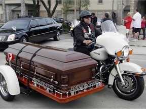 In this July 9, 2010, file photo, George Winney drives a motorcycle carrying the casket of Bob Probert as they depart Families First Funeral Home heading for Windsor Christian Fellowship for a funeral service for one of the toughest players in NHL history.