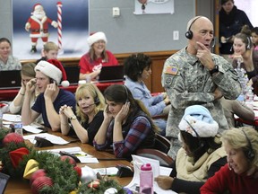 FILE - In this Dec. 24, 2014, file photo, NORAD Chief of Staff Maj. Gen. Charles D. Luckey takes a call while volunteering at the NORAD Tracks Santa center at Peterson Air Force Base in Colorado Springs, Colo. Hundreds of volunteers will help answer the phones from children around the world calling for Santa when the program resumes on Monday, Dec. 24, 2018, for the 63rd year.