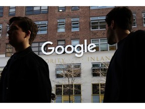 FILE - In this Dec. 4, 2017, file photo, people walk by Google offices in New York. Google is spending more than $1 billion to expand operations in New York City. Ruth Porat, senior vice president and chief financial officer at Google and Alphabet, said in a blog post Monday, Dec. 17, 2018, that Google is creating a more than 1.7 million square-foot campus that includes lease agreements along the Hudson River in lower Manhattan.