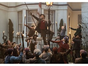 This image released by Disney shows Lin-Manuel Miranda, center, and Emily Blunt as Mary Poppins in "Mary Poppins Returns."
