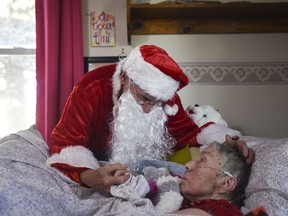 In this Saturday, Dec. 8, 2018 photo, Don West, 90, leans in to kiss his wife Jackie goodnight at Golden Days II Adult Foster Care in Charlotte following a Christmas party for residents and staff at the home. (Matthew Dae Smith/Lansing State Journal via AP) ORG XMIT: MILAN601