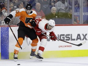 Philadelphia Flyers' Shayne Gostisbehere, left, and Detroit Red Wings' Andreas Athanasiou collide during the first period of an NHL hockey game, Tuesday, Dec. 18, 2018, in Philadelphia.