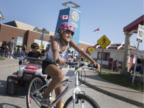 In this Aug. 16, 2017, file photo, Nadine Abdallah, 10, practices bike safety during a Walk-In Wednesday offering at the Children's Safety Village. Children are given education safety classes while representatives from Windsor Fire and Rescue, Windsor Police Service, EMS Paramedics and the Essex Windsor Port Authority show what they do.