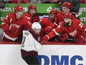 From left background, Detroit Red Wings' Dylan Larkin, Tyler Bertuzzi, Luke Glendening, Michael Rasmussen and Luke Witkowski push away Colorado Avalanche left wing Matt Calvert after Calvert got his stick held by Glendening during the third period of an NHL hockey game in Detroit, Sunday, Dec. 2, 2018. The Avalanche defeated the Red Wings 2-0.
