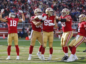 San Francisco 49ers tight end George Kittle (85) is greeted by his teammates after scoring a touchdown during the first half of an NFL football game against the Denver Broncos Sunday, Dec. 9, 2018, in Santa Clara, Calif. At left, is wide receiver Dante Pettis (18) and at right is quarterback Nick Mullens.