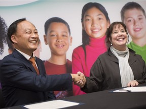 Seok-ho Kim, principal at Yuhan Technical High School in South Korea, shakes hands with Erin Kelly, director of education for the Greater Essex County District School Board, after signing a memorandum of understanding, Monday, December 3, 2018.
