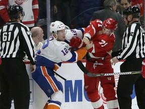 New York Islanders right wing Josh Bailey (12) fights with Detroit Red Wings center Dylan Larkin (71) during the first period of an NHL hockey game Saturday, Dec. 8, 2018, in Detroit.