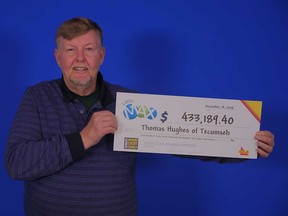 Thomas Hughes, 66, of Tecumseh, holds up the $433,189 prize cheque he won from the Lotto MAX draw of Nov. 16, 2018.