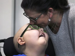Huntre Allard, 9, gets a kiss from his mother Lisa Marchand-Aylesworth after to seeing his new redesigned bedroom on Tuesday, December 11, 2018 at his Windsor home. The Make-a-Wish Foundation granted Huntre's wish for a John Deere themed bedroom.