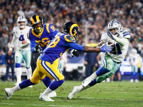Inside linebacker Cory Littleton #58 of the Los Angeles Rams tackles running back Ezekiel Elliott #21 of the Dallas Cowboys in the fourth quarter of the NFC Divisional Round playoff game at Los Angeles Memorial Coliseum on January 12, 2019 in Los Angeles, California.