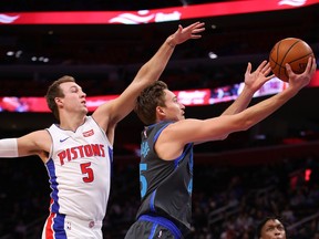 DETROIT, MICHIGAN - JANUARY 31:  Ryan Broekhoff #45 of the Dallas Mavericks drives to the basket past Luke Kennard #5 of the Detroit Pistons during the first half at Little Caesars Arena on January 31, 2019 in Detroit, Michigan. NOTE TO USER: User expressly acknowledges and agrees that, by downloading and or using this photograph, User is consenting to the terms and conditions of the Getty Images License Agreement.