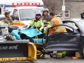 Windsor firefighters and Essex-Windsor EMS paramedics remove an injured woman from a Chevrolet Cobalt following a two-vehicle collision In the eastbound lane of Erie Street East at Hall Avenue on Jan. 18, 2019. Windsor Police were on scene investigating.