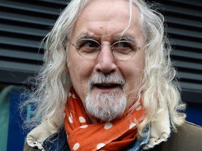 Scottish comedian Billy Connolly stops to speak to the media after leaving floral tributes near The Clutha Bar, on Dec. 3, 2013 in Glasgow, Scotland.