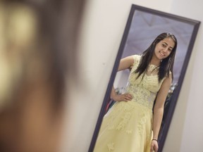 Sally Elsayed, 18, a grade 12 student at St. Joseph High School, tries on a prom dress at Say Yes to the Prom Dress at New Beginnings Saturday, March 18, 2017.