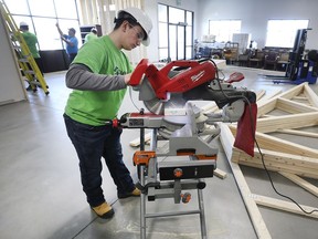 Michael Polegato, a high school student with the Windsor Essex Catholic District School Board's Construction Academy cuts a board at the Habitat for Humanity Windsor-Essex new location on Edinborough Street. The students were helping build section of the new facility.