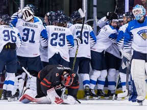 Canada goalie Michael DiPietro, front, kneels on the ice after Finland defeated Canada during overtime quarter-final IIHF world junior hockey championship action in Vancouver on Jan. 2, 2019.