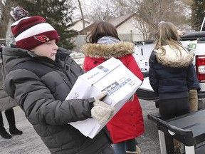 Carson Bildfell carries a box of the items as students from Colchester North Public School deliver more than 1,000 items — from toothpaste to juice boxes — to the Hospice of Windsor and Essex County on Friday, Jan. 25, 2019.
