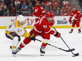 Nashville Predators center Rocco Grimaldi (23) tries to steal the puck from Detroit Red Wings center Luke Glendening (41) in the first period of an NHL hockey game Friday, Jan. 4, 2019, in Detroit.