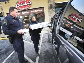 Canadian Customs and Immigration officers Mike Bechard and Sandrine Fleurancois pick up pizzas at Antonino's Pizza in Windsor on Jan. 18, 2019. The Canadian officers were buying and delivering the pizzas to their U.S. counterparts who have been working without pay due to the partial government shut down in the U.S.