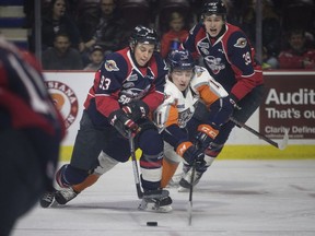 Windsor's Jean-Luc Foudy attempts to keep the puck from Flint's Dennis Busby in OHL action between the Windsor Spitfires and the Flint Firebirds at the WFCU Centre on Thursday.