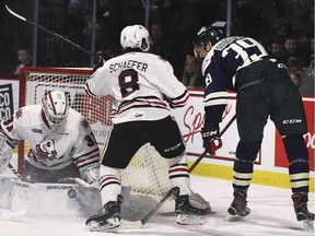 Windsor Spitfires forward Curtis Douglas, far right, is denied by Niagara IceDogs goalie Jake McGrath while Niagara defenceman Johnathon Shaefer tries to hold him off during Sunday's game at the WFCU Centre.