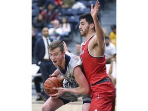 Thomas Kennedy, left, of the University of Windsor Lancers, battles Daniel Cayer of the Brock Badgers, during Saturday's OUA men's basketball game at the St. Denis Centre.