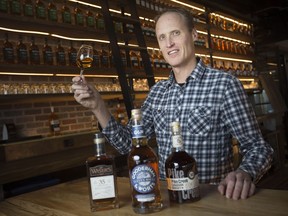 Dr. Don Livermore, master blender at Hiram Walker and Sons Distilllery, stands behind three award-winning bottles of whisky on Jan. 21, 2019. From left, J.P. Wiser's 35 years, Gooderham and Worts Eleven Souls, and Pike Creek 10 year Rum Barrel Finish.
