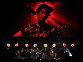 Singer Ryan Adams performs with his band underneath an image of the late singer Chris Cornell during "I Am The Highway: A Tribute to Chris Cornell" at The Forum, Wednesday, Jan. 16, 2019, in Inglewood, Calif.