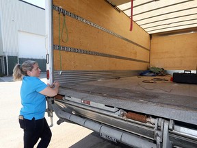 Fiona Coughlin, executive director of Habitat for Humanity Windsor-Essex, looks into the emptied cargo hold of the organization's truck in this September 2018 file photo.