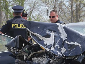 OPP officers discuss the discovery of firearms on the two occupants of a Lexus sedan that collided head-on with another vehicle on Highway 3 on April 26, 2017.