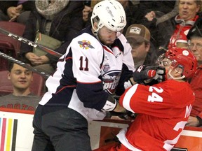 Windsor Spitfires defenceman Sean Allen checks Sault Ste. Marie Greyhounds forward Cole MacKay during first-period action on Friday at  the GFL Memorial Gardens.