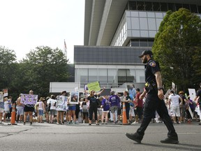 FILE - In this Aug. 17, 2018 file photo, family and friends who have lost loved ones to OxyContin and opioid overdoses protest outside Purdue Pharma headquarters in Stamford, Conn. The Sackler family's ties to OxyContin and the painkiller's role in the deadly opioid crisis are bringing the Sacklers a new kind of attention and complicating their philanthropic legacy.