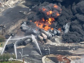Smoke rises from railway cars that were carrying crude oil after derailing in downtown Lac-Megantic, Que., Saturday, July 6, 2013.