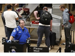 A TSA worker helps passengers at the Salt Lake City International Airport, Wednesday, Jan. 16, 2019, in Salt Lake City. The government shutdown has generated an outpouring of generosity to TSA agents and other federal employees who are working without pay. In Salt Lake City, airport officials treated workers from the TSA, FAA and Customs and Border Protection to a free barbecue lunch as a gesture to keep their spirits up during a difficult time.