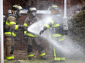 A Windsor firefighter receives a washdown after leaving the interior of a burning home at 354 Partington Avenue February 4, 2019. Six students were living at the home, though only one resident was home at the time of the fire.  Nobody was injured. The home sustained heavy damage to all three floors.