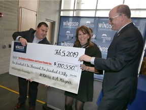 Adam Wagner, left, of Windsor Championship hands over a cheque of $110,550 to Colleen Reaume, executive director of The Hospice of Windsor and Essex County Inc. during a press conference for the Mackenzie Tour's Windsor Championship at City Hall Feb. 5, 2019.  Assisting was Windsor Mayor Drew Dilkens, right.