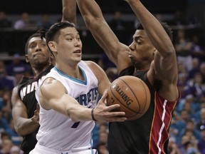 FILE - In this April 25, 2016 file photo, Charlotte Hornets' Jeremy Lin, center, passes the ball as Miami Heat's Hassan Whiteside, right, and Josh Richardson, left, defend during the first half in Game 4 of an NBA basketball playoffs first-round series in Charlotte, N.C.  Lin agreed to a three-year, $36 million contract Friday, July 1, with the Brooklyn Nets, a person with knowledge of the details told The Associated Press.