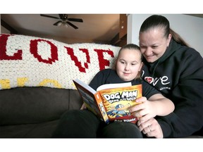 April Pare reads with daughter Adyson, 7, at their family home Monday.