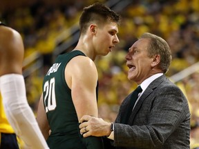 Head coach Tom Izzo of the Michigan State Spartans talks to Matt McQuaid #20 while playing the Michigan Wolverines at Crisler Arena on February 24, 2019 in Ann Arbor, Michigan. Michigan State won the game 77-70.