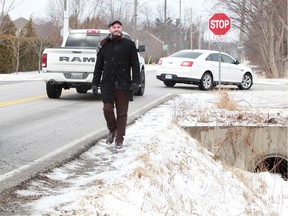 With a deep ditch on one side and traffic on the other, city councillor Kieran McKenzie walks the dangerous path along 6th Concession near Holburn Street.  To make matter worse, there's a Transit Windsor bus stop on the same corner.