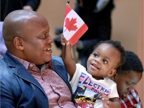 Already a Canadian citizen by birth, Sarah Jobome, 1, waves a Canadian flag as her father Patrick Jobome and family prepare to take the Oath of Citizenship during a ceremony presided by Robert Bruce at the Alzheimer Society of Windsor and Essex County hall on Richmond Street Thursday. Patrick Jobome was born in Nigeria.